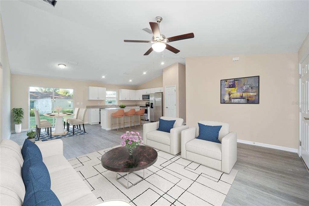 A bright open-concept living room and kitchen featuring light wood floors and modern furniture — 14162 SW 16TH PLACE, DUNNELLON, FL