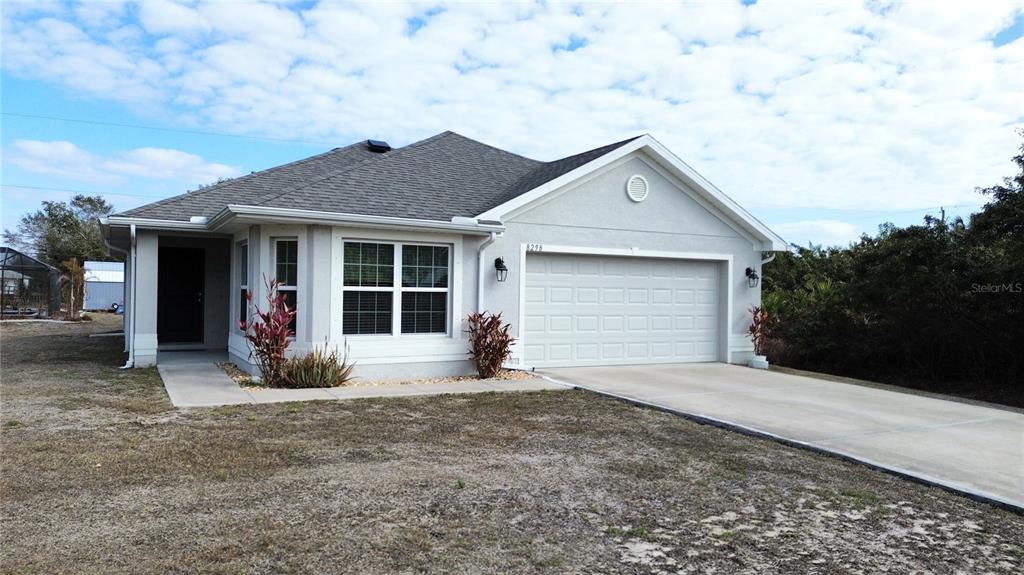 A single-story house with a gray exterior, a two-car garage, and a concrete driveway — 8298 OSBERT AVENUE, NORTH PORT, FL