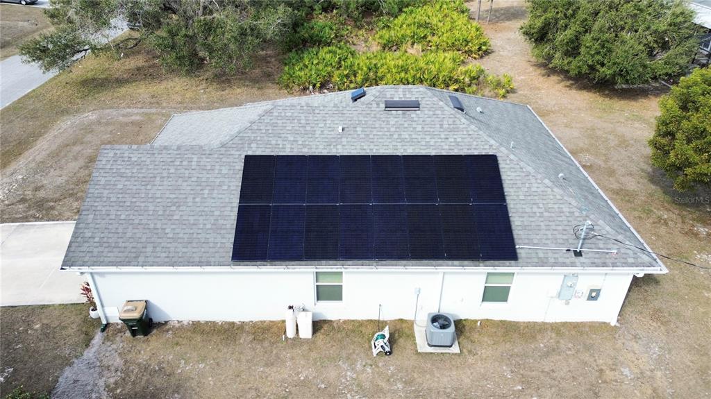 An aerial view shows a house roof with a large solar panel array installed — 8298 OSBERT AVENUE, NORTH PORT, FL