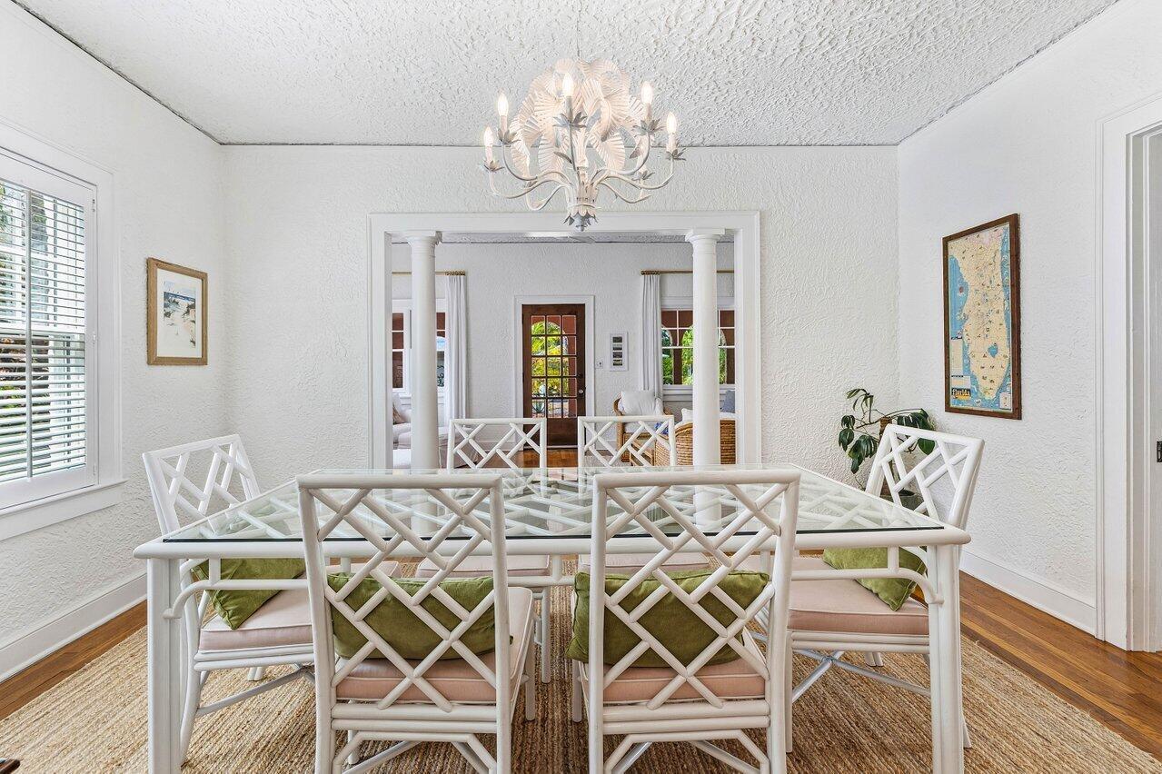 A dining room features a glass-topped table, white bamboo-style chairs, and a decorative chandelier — 217 SE Coconut Avenue, Stuart FL 34996, STUART, FL