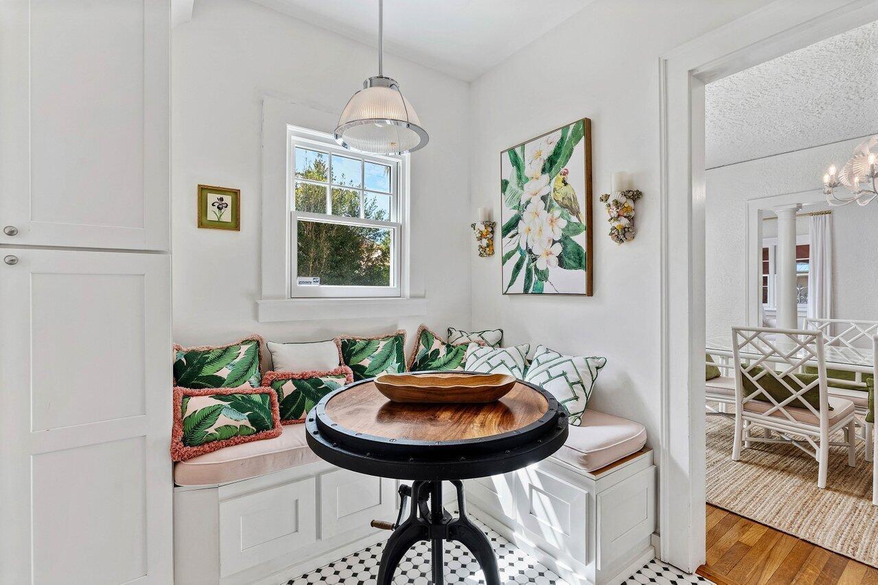 A breakfast nook features a built-in corner bench, a round industrial table, and patterned pillows — 217 SE Coconut Avenue, Stuart FL 34996, STUART, FL