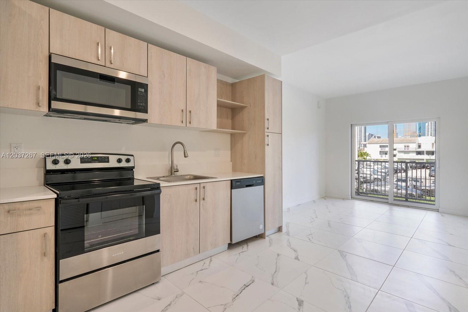 A kitchen with light wood cabinets, stainless steel appliances, and white marble-patterned tile flooring — 420 SW 7th Ave # 204, Miami FL 33130, MIAMI, FL