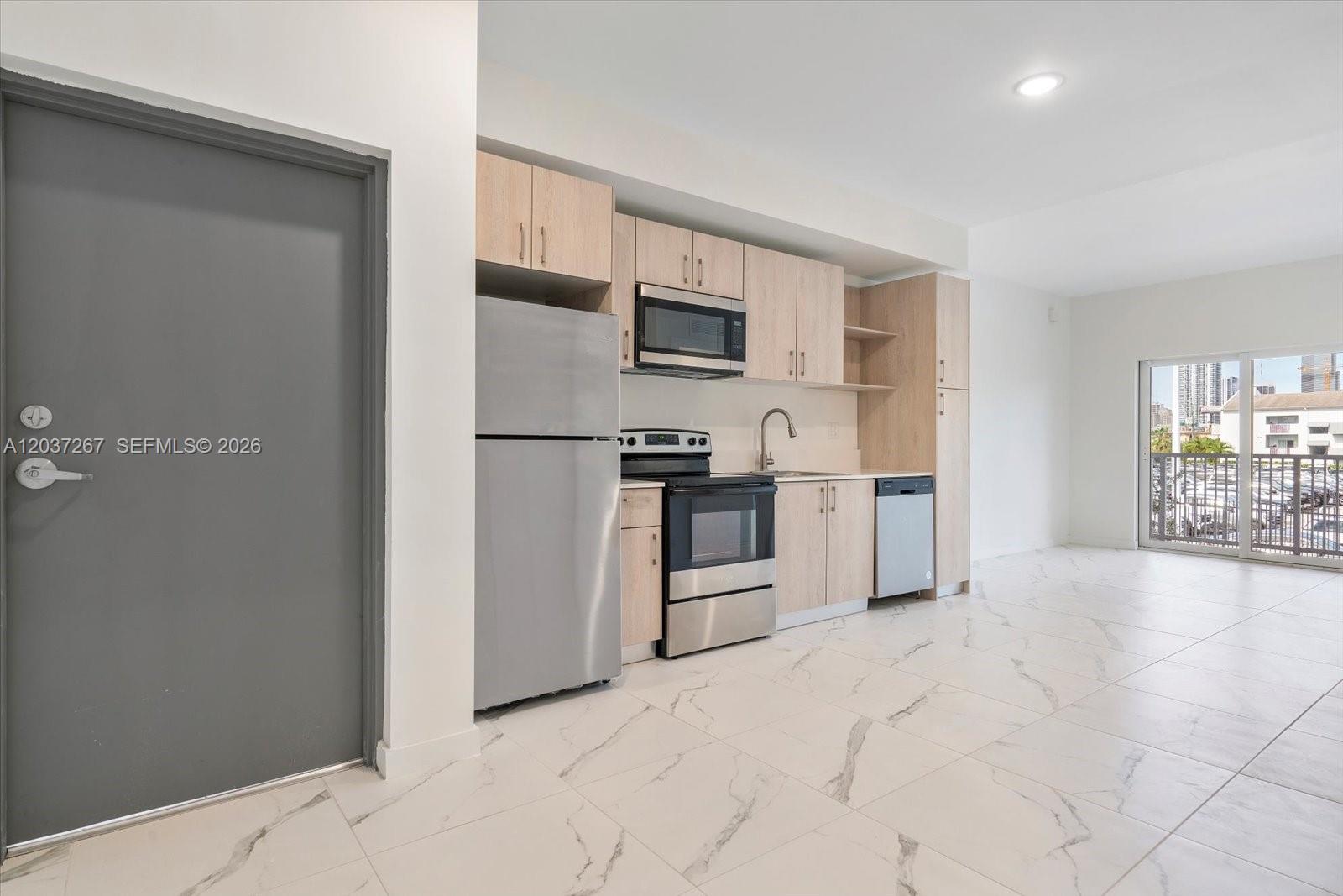 A kitchen with light wood cabinets, stainless steel appliances, and white marble-patterned tile flooring — 420 SW 7th Ave # 204, Miami FL 33130, MIAMI, FL