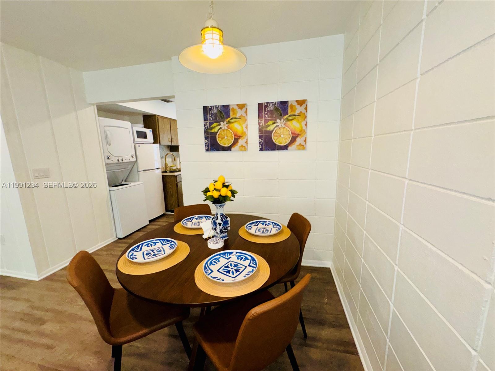 A dining area features a round wooden table, four chairs, and white block walls — 5100 Rilma Ave # 0, Sarasota FL 34234, SARASOTA, FL