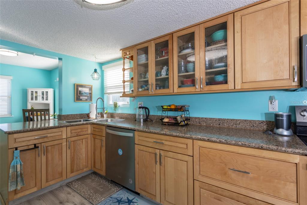 A kitchen features light wood cabinets, granite countertops, and bright turquoise walls — 44 FLAGLER DRIVE, PALM COAST, FL