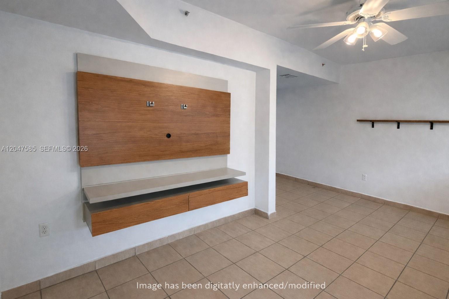 A room features a wall-mounted wooden media console, tiled floors, and a ceiling fan — 318 E 6th St # 102, Hialeah FL 33010, HIALEAH, FL