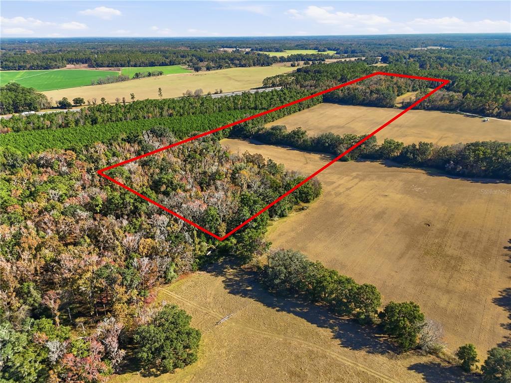 An aerial view shows a rectangular plot of land outlined in red amidst fields — OLD BELLAMY RD, HIGH SPRINGS, FL