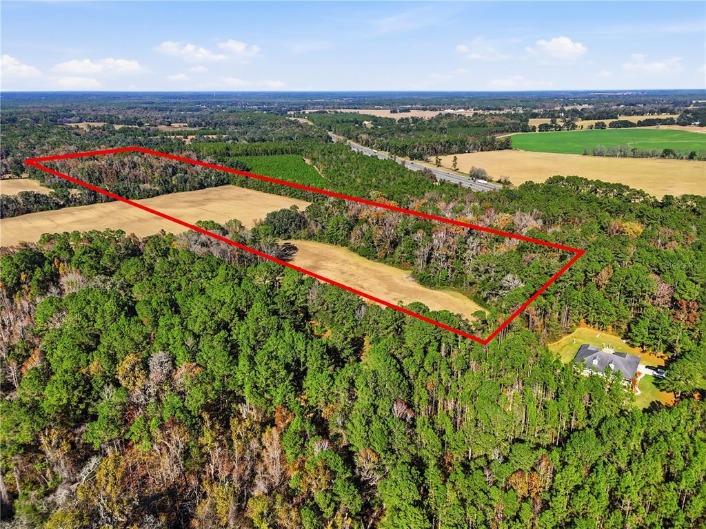 An aerial view shows a rectangular plot of land outlined in red near a house — OLD BELLAMY RD, HIGH SPRINGS, FL
