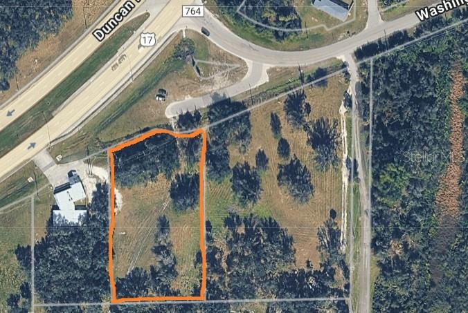 An aerial view shows a rectangular plot of land outlined in orange near a highway — 4224 DUNCAN ROAD, PUNTA GORDA, FL