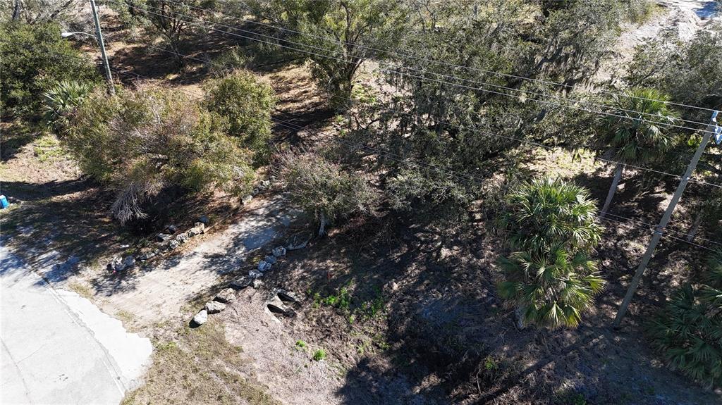 An aerial view shows a wooded lot with a dirt driveway and utility poles — 4224 DUNCAN ROAD, PUNTA GORDA, FL