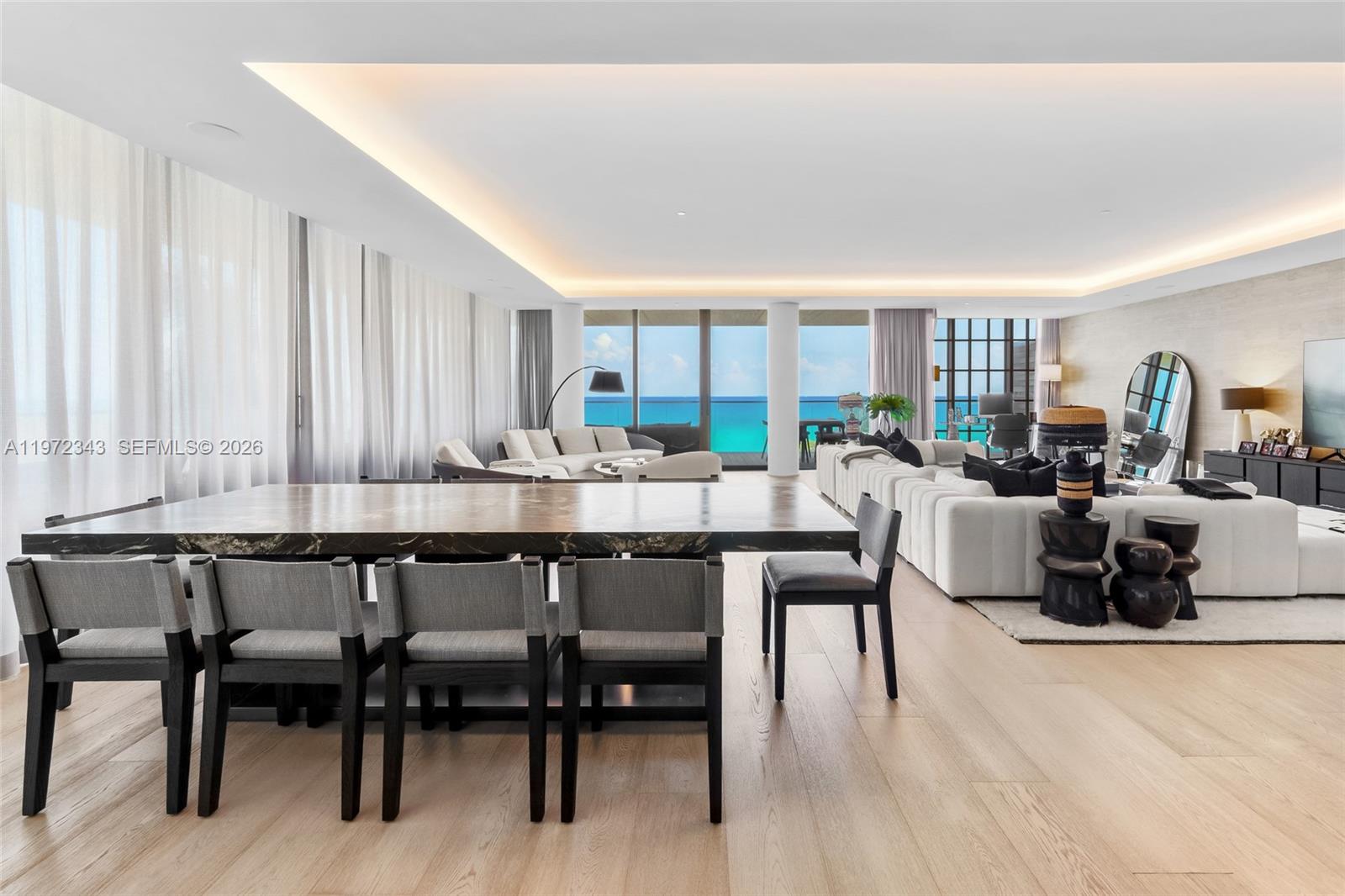 A spacious, modern living and dining area features floor-to-ceiling windows with ocean views — 8955 NE Collins Ave # 301, Surfside FL 33154, SURFSIDE, FL