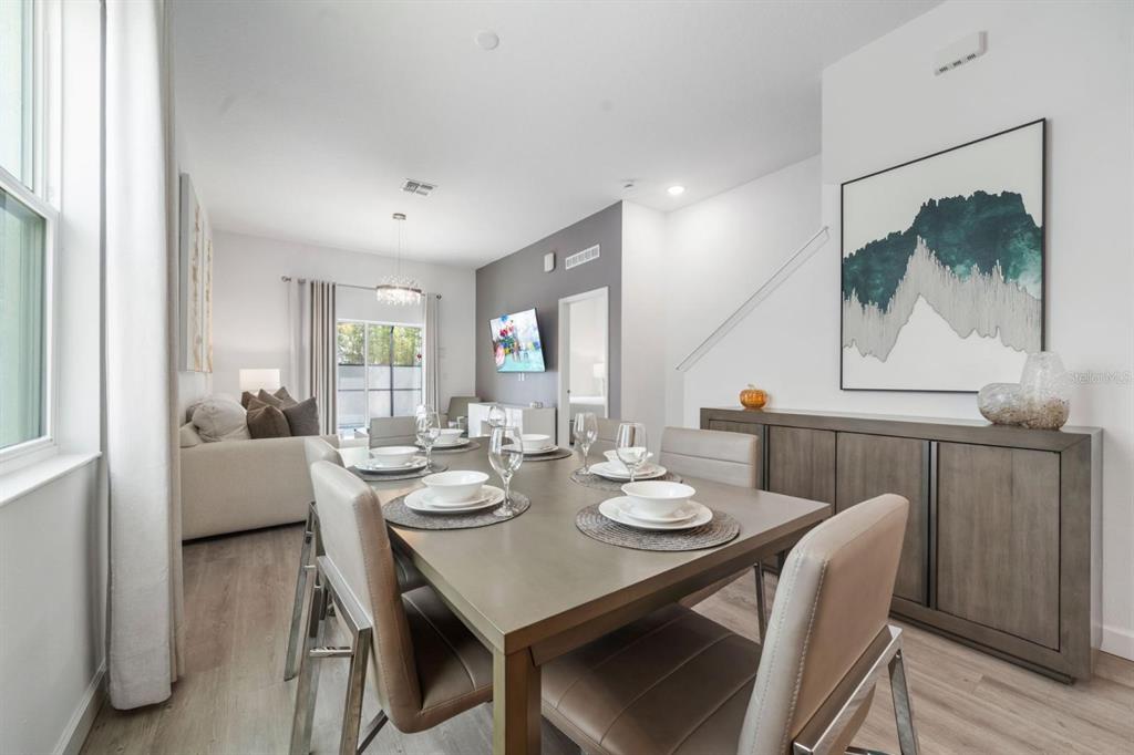 A dining area with a table set for four, adjacent to a living room space — 384 FAMAGUSTA DRIVE, DAVENPORT, FL