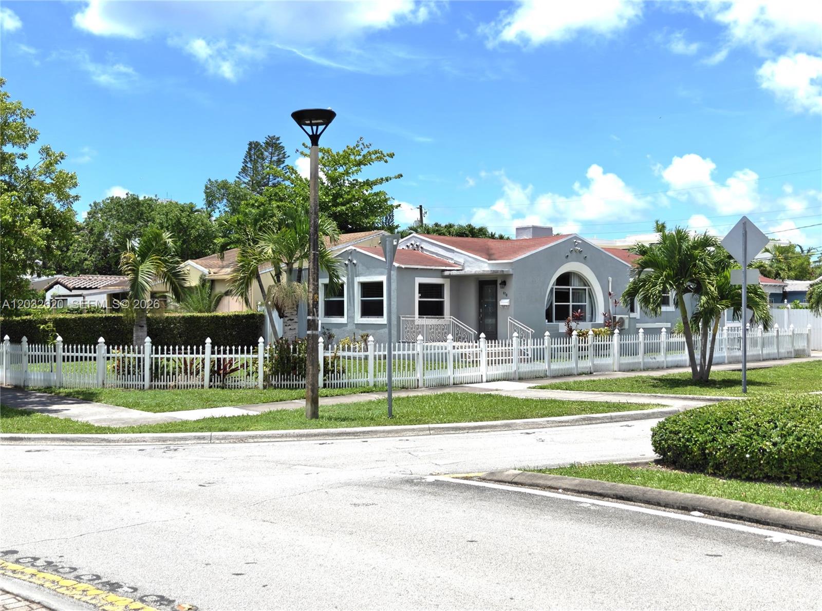 A gray house with a red roof and white picket fence sits on a corner lot — 470 SW 25th Rd, Miami FL 33129, MIAMI, FL