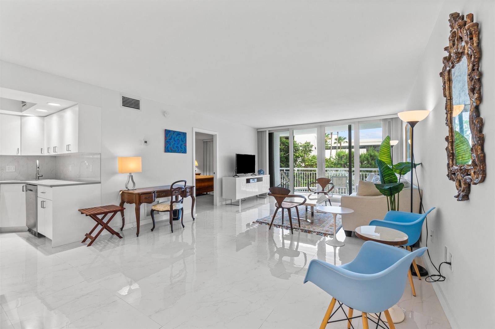A bright, open-concept living room and kitchen area features white tile floors and balcony access — 2780 S Ocean Boulevard # 306, Palm Beach FL 33480, PALM BEACH, FL