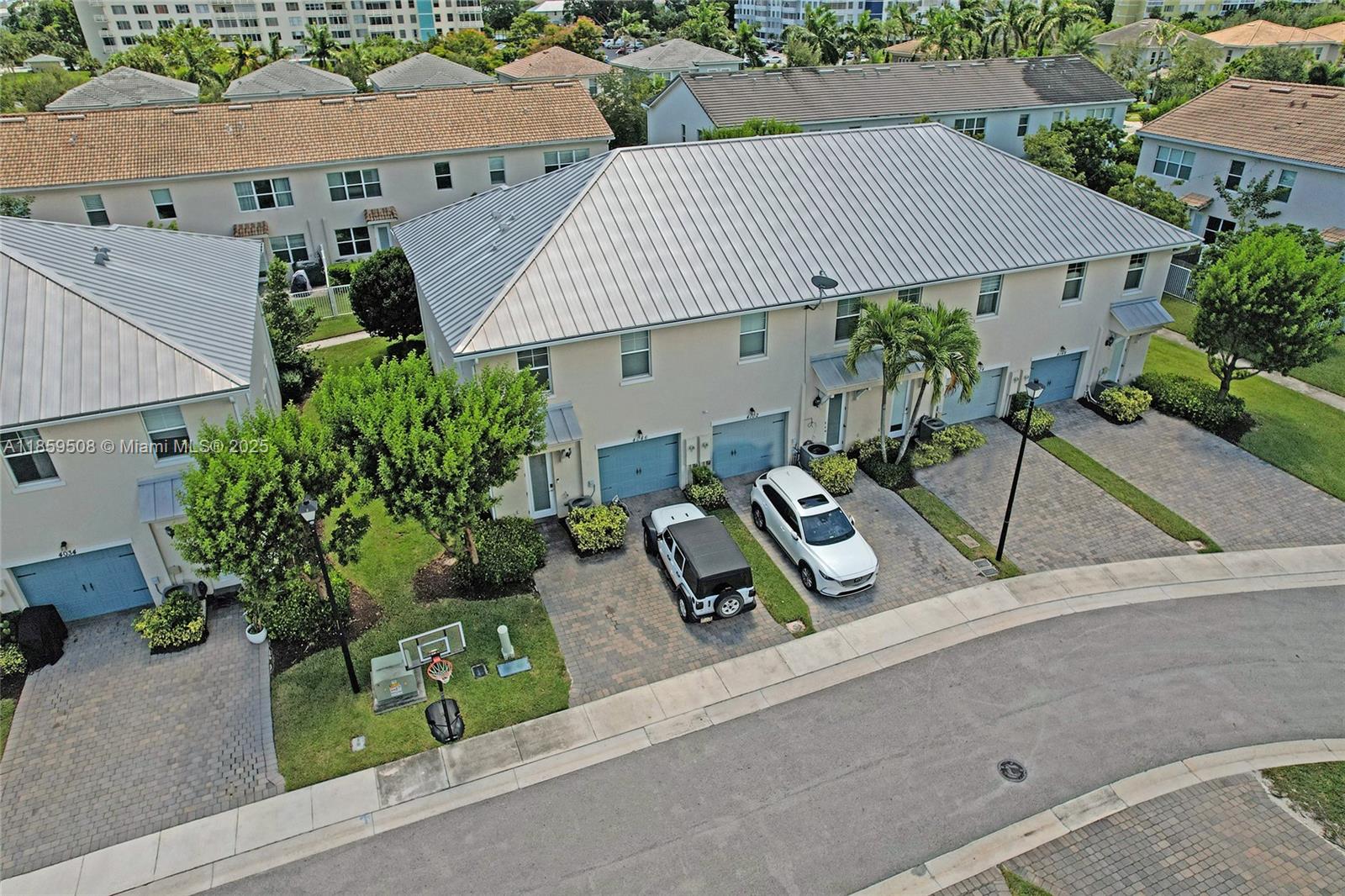 An aerial view shows a row of townhouses with metal roofs and paved driveways — 4046 Long Leaf Ln, Hollywood FL 33021, HOLLYWOOD, FL