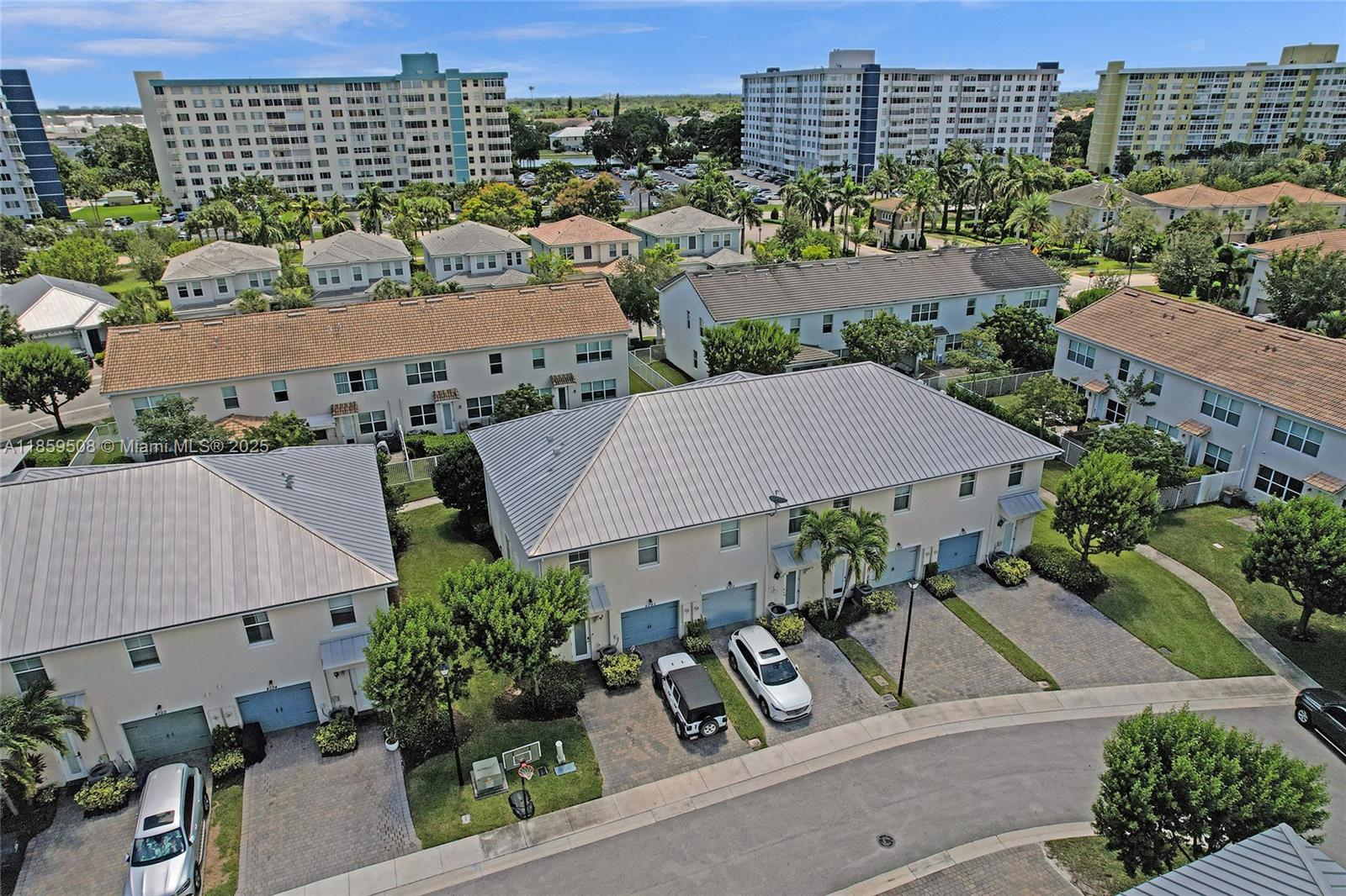 An aerial view shows several multi-story townhouses with metal roofs and paved driveways — 4046 Long Leaf Ln, Hollywood FL 33021, HOLLYWOOD, FL