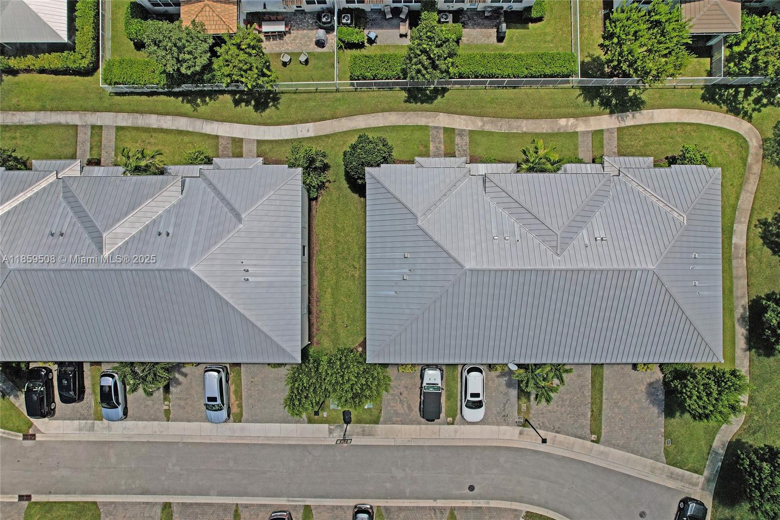 An aerial view shows two residential buildings with metal roofs and adjacent paved driveways — 4046 Long Leaf Ln, Hollywood FL 33021, HOLLYWOOD, FL