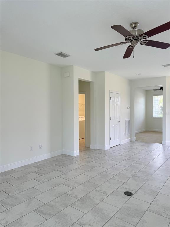 A room with light-colored tile flooring, a ceiling fan, and a doorway leading to another room — 5057 NW 35TH PLACE, OCALA, FL
