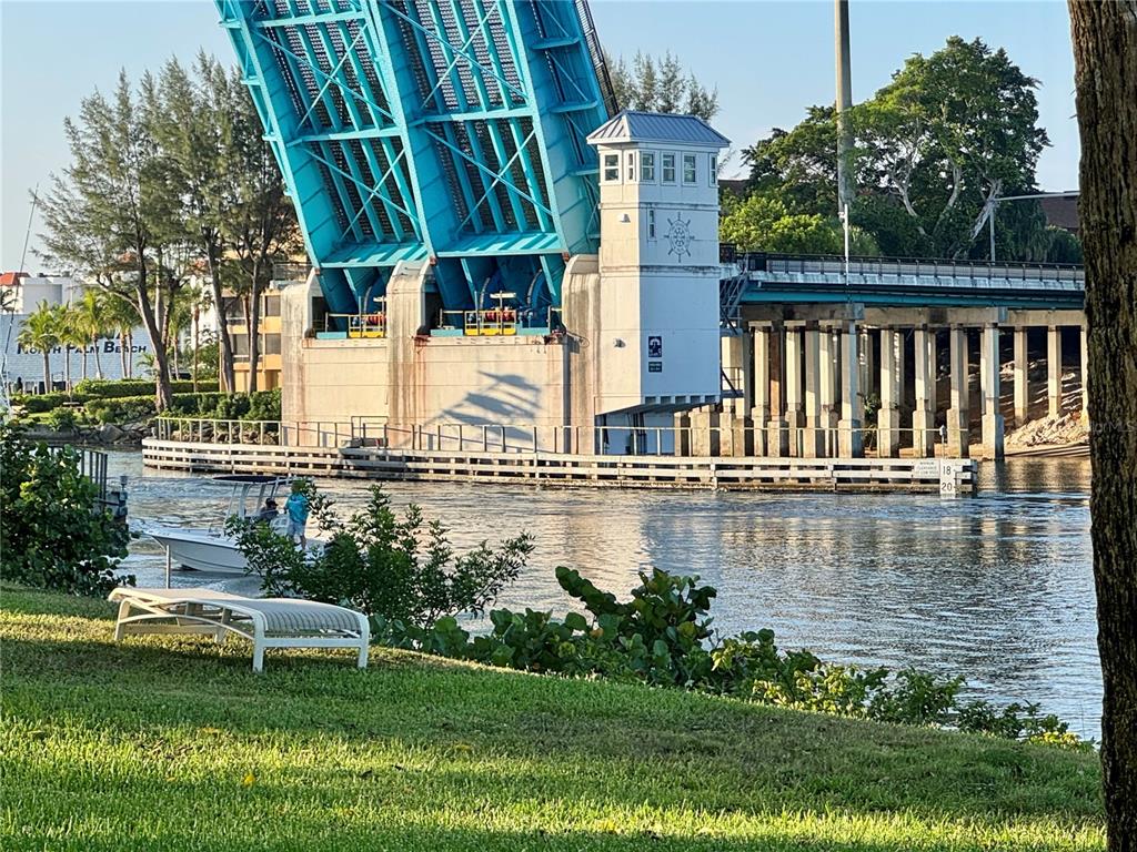 A drawbridge is raised over a waterway with a small boat passing underneath — 304 GOLFVIEW ROAD UNIT PH7, NORTH PALM BEACH, FL