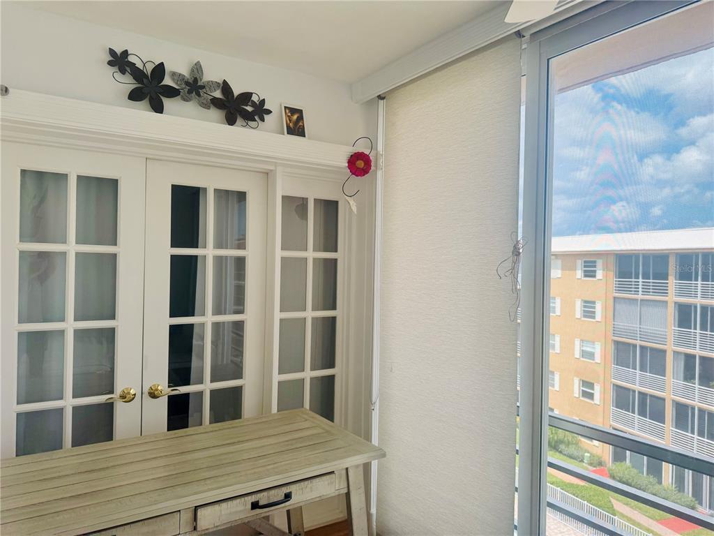 A desk sits in front of French doors beneath wall-mounted flower decor near a window — 304 GOLFVIEW ROAD UNIT PH7, NORTH PALM BEACH, FL
