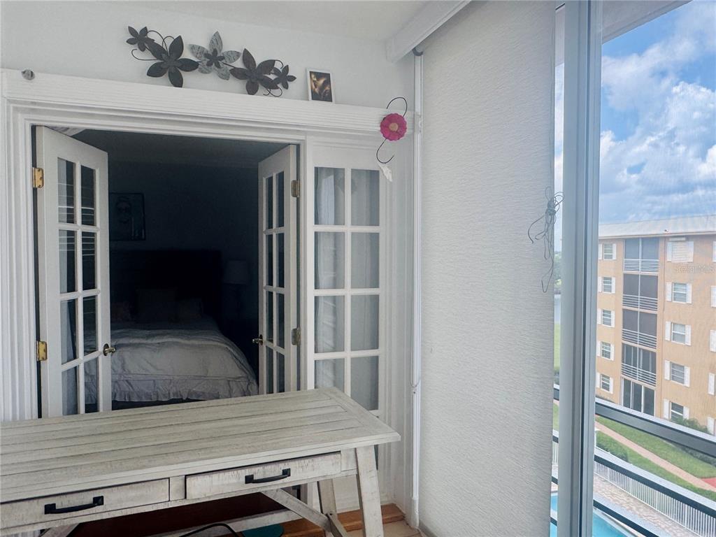 A white desk sits in a sunroom looking through French doors into a bedroom — 304 GOLFVIEW ROAD UNIT PH7, NORTH PALM BEACH, FL