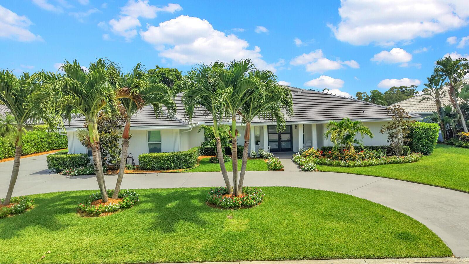 A single-story house with a gray tile roof, palm trees, and a curved concrete driveway — 341 Glenbrook Drive, Atlantis FL 33462, ATLANTIS, FL