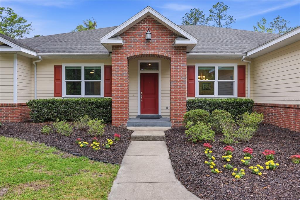 A rectangular swimming pool with steps sits on a concrete patio beside a wooden fence — 9208 NW 64TH TERRACE, GAINESVILLE, FL