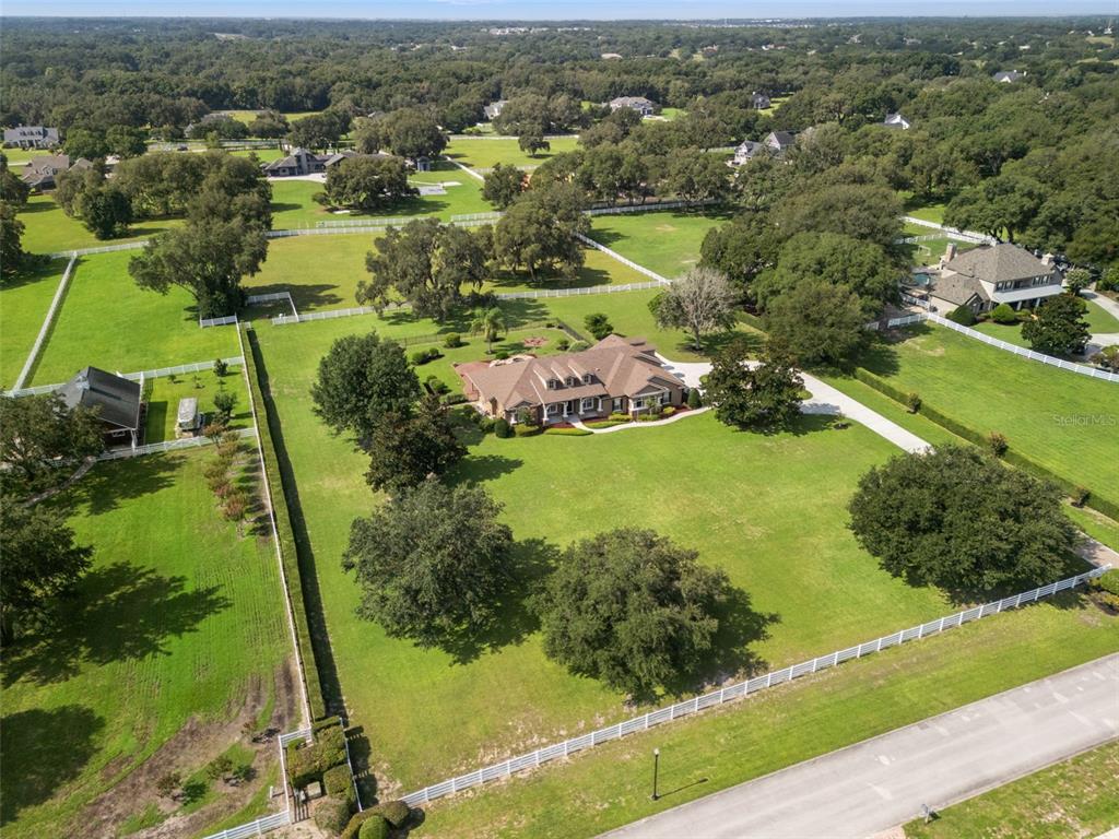 An aerial view shows a large house with a brown roof on a grassy lot — 351 KENTUCKY BLUE CIRCLE, APOPKA, FL