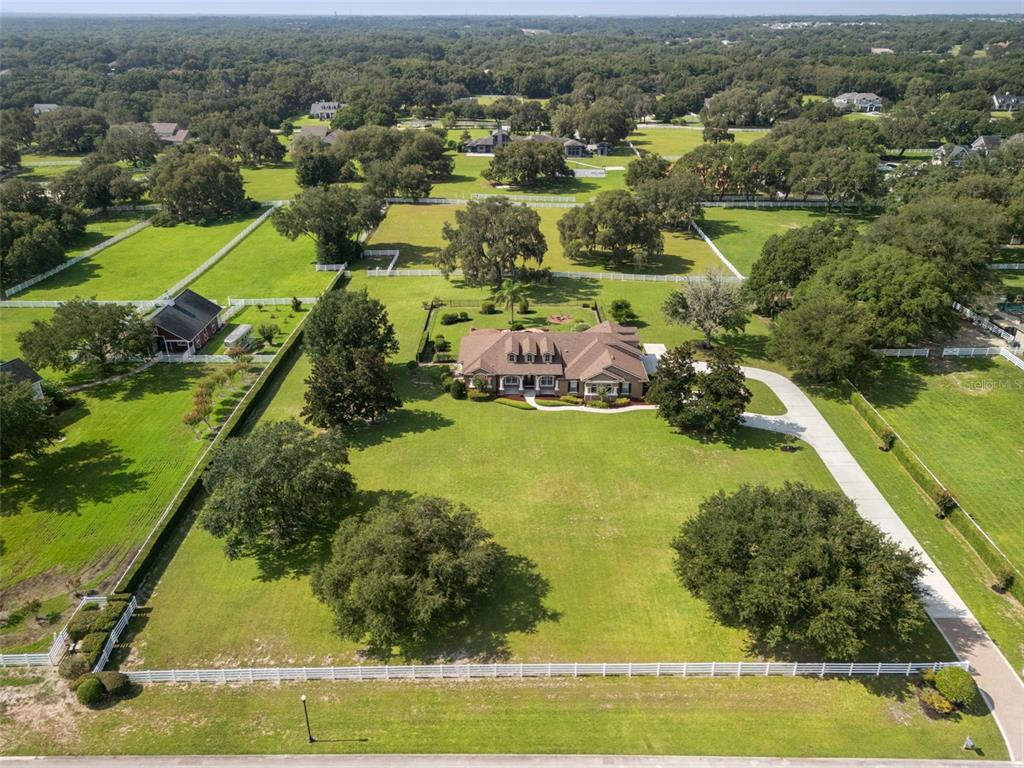 An aerial view shows a large house with a driveway situated on a grassy lot — 351 KENTUCKY BLUE CIRCLE, APOPKA, FL