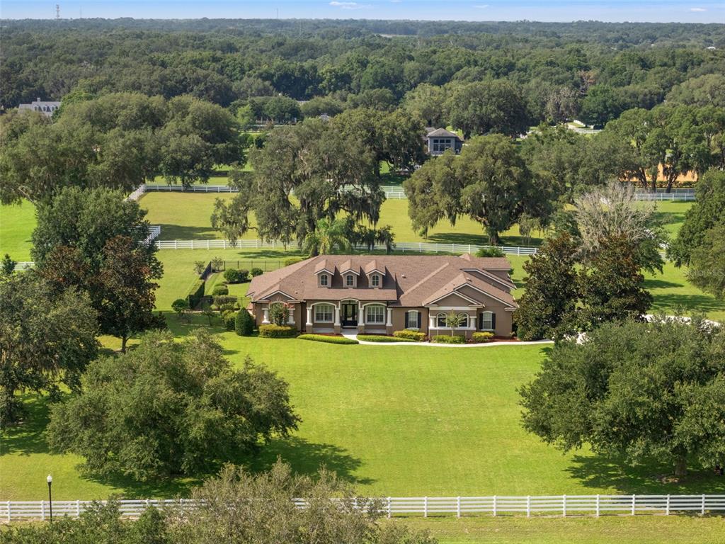 An aerial view shows a single-story house with a brown roof surrounded by green lawns — 351 KENTUCKY BLUE CIRCLE, APOPKA, FL