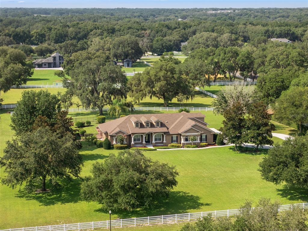 An aerial view of a large house with a brown roof surrounded by green pastures — 351 KENTUCKY BLUE CIRCLE, APOPKA, FL