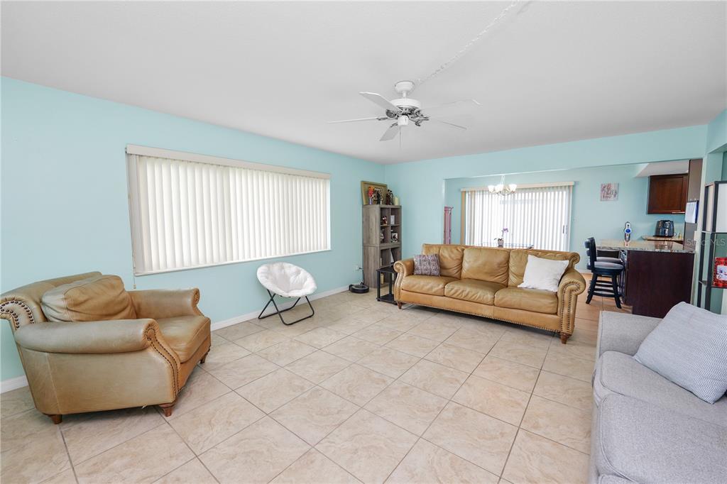 A living room with light blue walls, tile flooring, and tan leather furniture — 711 BARBER CIRCLE UNIT 711, LAKELAND, FL