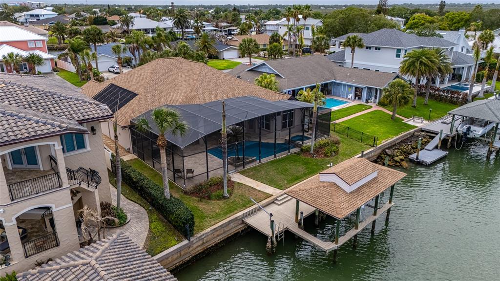 An aerial view of a waterfront house with a screened pool and a private boat dock — 133 VIA CAPRI, NEW SMYRNA BEACH, FL