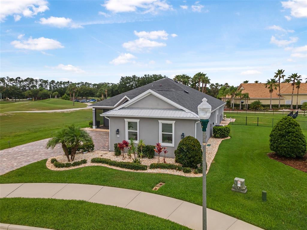 An exterior view of a gray single-story house with a paved driveway and landscaped yard — 2948 BELLA FLORE TERRACE, NEW SMYRNA BEACH, FL