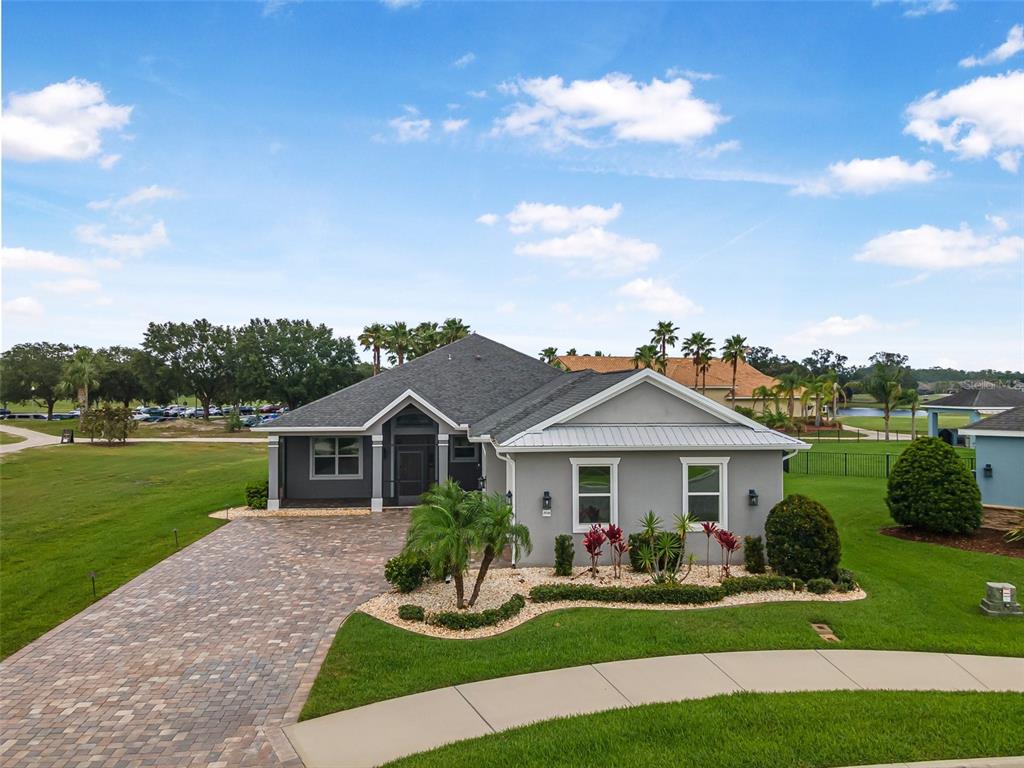 A single-story gray house with a paved driveway and landscaped front yard under a blue sky — 2948 BELLA FLORE TERRACE, NEW SMYRNA BEACH, FL