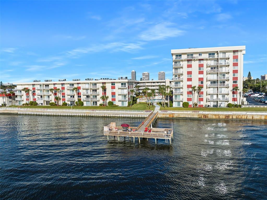 An aerial view shows a waterfront apartment complex with a wooden pier extending into water — 2711 N HALIFAX AVENUE UNIT 890, DAYTONA BEACH, FL