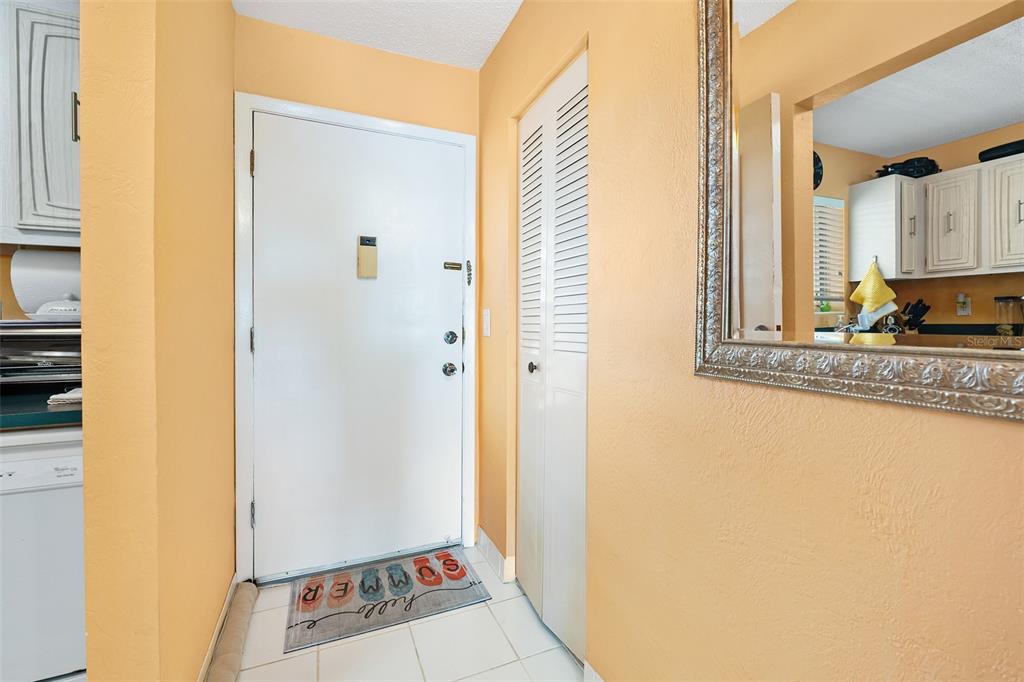 An entryway features a white door, a louvered closet door, and a tiled floor — 2711 N HALIFAX AVENUE UNIT 890, DAYTONA BEACH, FL