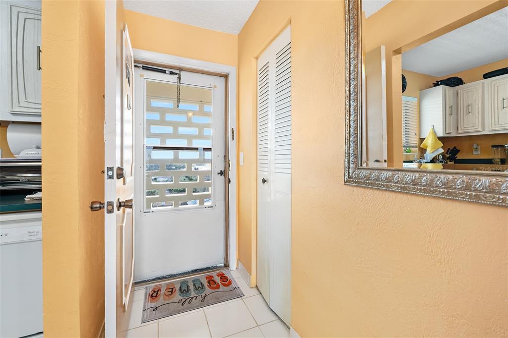 An entryway features a white door with a glass insert, tiled floors, and a wall mirror — 2711 N HALIFAX AVENUE UNIT 890, DAYTONA BEACH, FL