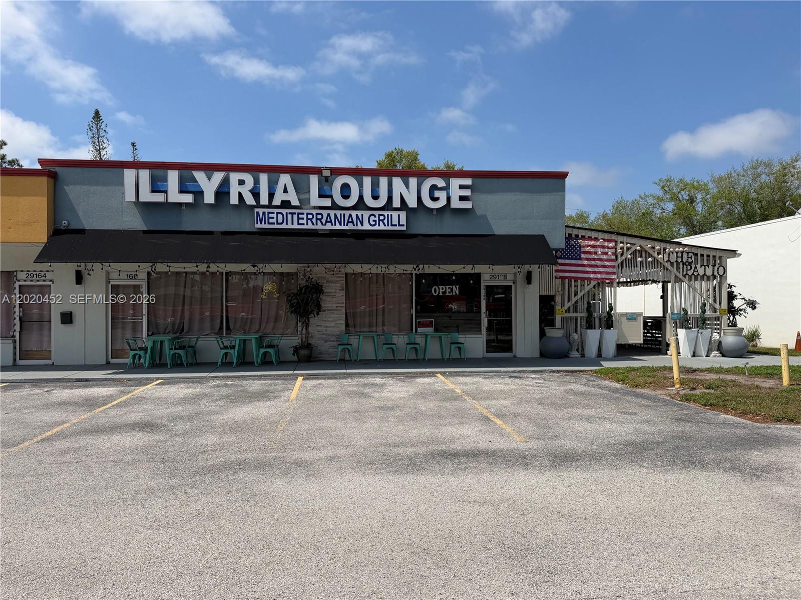 The exterior of a Mediterranean grill restaurant features a parking lot and an outdoor patio — 29168 N US HWY 19, Clearwater FL 33761, CLEARWATER, FL