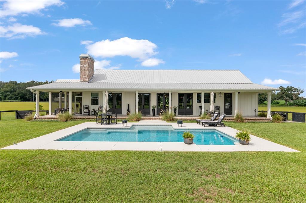 A single-story house with a metal roof and a swimming pool in the backyard — 2152 NE 120TH PLACE, ANTHONY, FL
