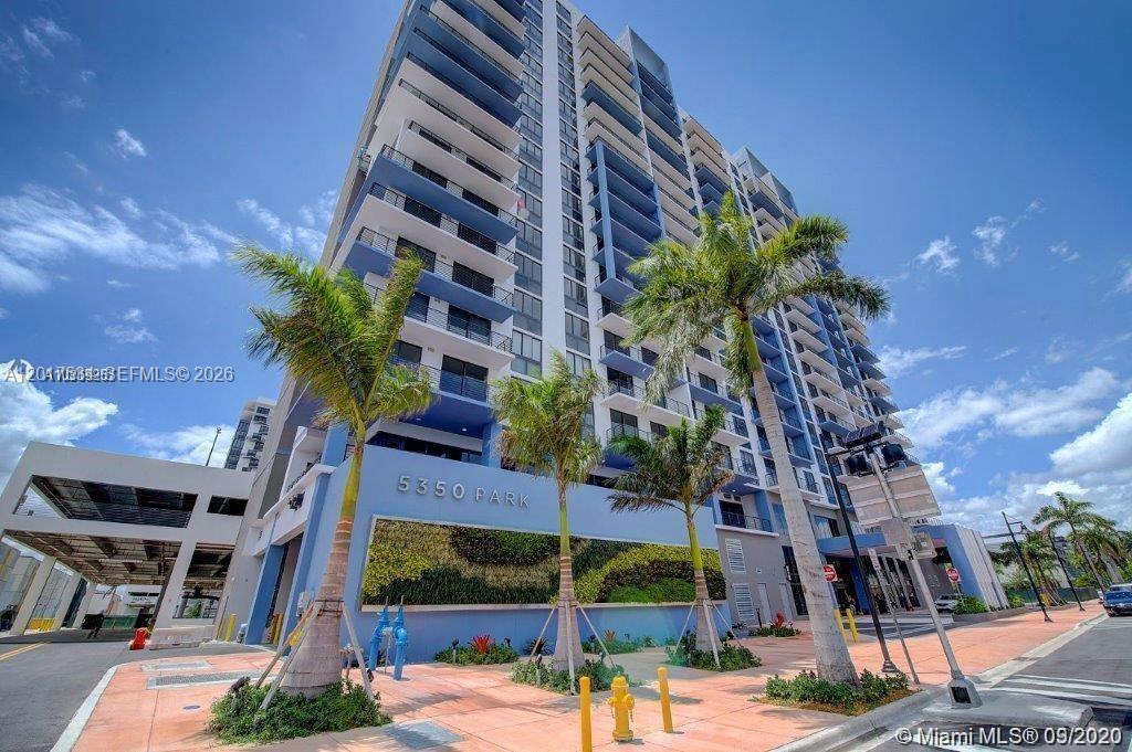 A low-angle exterior view of a modern high-rise residential building with a green wall — 5350 NW 84th Ave # 1613, Doral FL 33166, DORAL, FL