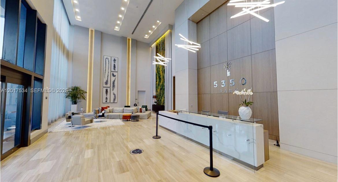 A modern building lobby features a white reception desk, high ceilings, and a seating area — 5350 NW 84th Ave # 1613, Doral FL 33166, DORAL, FL