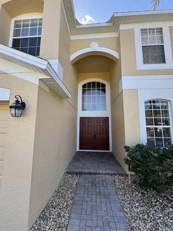 The exterior of a two-story home features a brick walkway leading to double front doors — 806 LOST GROVE CIRCLE, WINTER GARDEN, FL