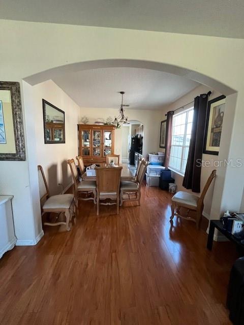 A dining room with hardwood floors, an arched entryway, and a wooden hutch — 806 LOST GROVE CIRCLE, WINTER GARDEN, FL