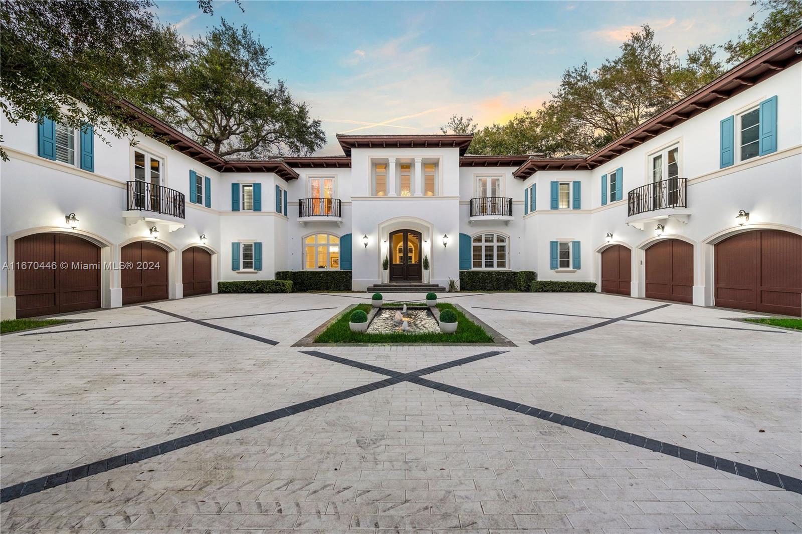 A large white Mediterranean-style mansion features a symmetrical facade, multiple garage doors, and a courtyard — 5225 Fairchild Way, Coral Gables FL 33156, CORAL GABLES, FL