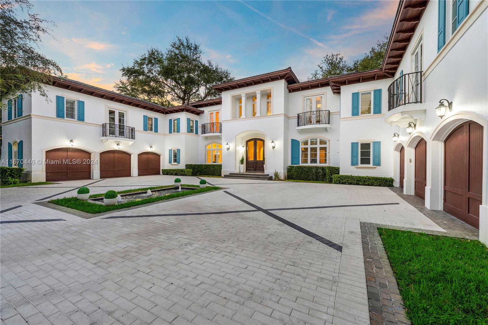 A large white Mediterranean-style house features a paved courtyard with a fountain and multiple garages — 5225 Fairchild Way, Coral Gables FL 33156, CORAL GABLES, FL