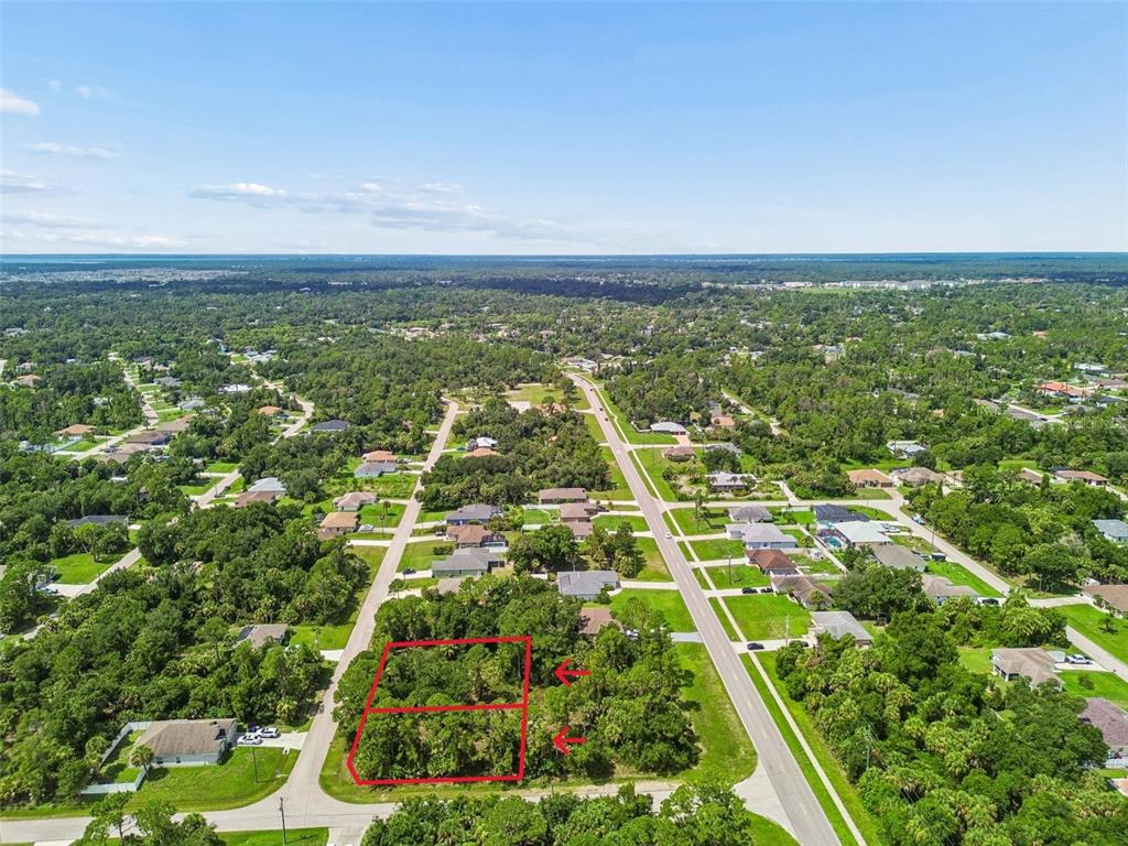 An aerial view shows two adjacent, wooded vacant lots outlined in red near a road — 15 HEATHER TERRACE, NORTH PORT, FL