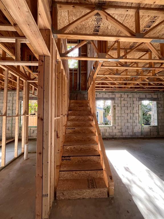 An interior view of a house under construction showing wooden framing, stairs, and concrete walls — 485 11TH AVENUE N, ST PETERSBURG, FL