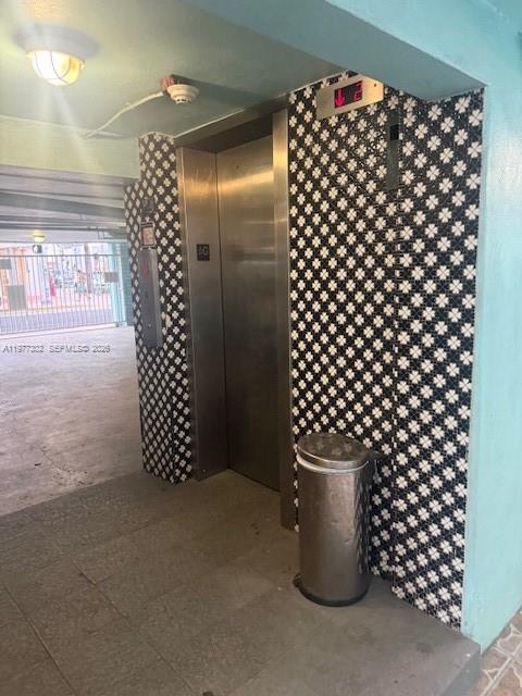 An elevator with a stainless steel door is set against a black and white tiled wall — 701 Collins Ave # 2B, Miami Beach FL 33139, MIAMI BEACH, FL