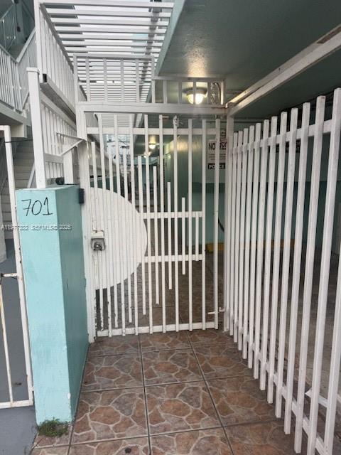A white metal gate stands at the entrance of a building marked with number 701 — 701 Collins Ave # 2B, Miami Beach FL 33139, MIAMI BEACH, FL